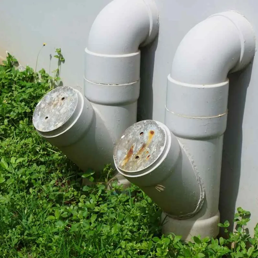 Exterior sewer cleanout access points at the side of a property